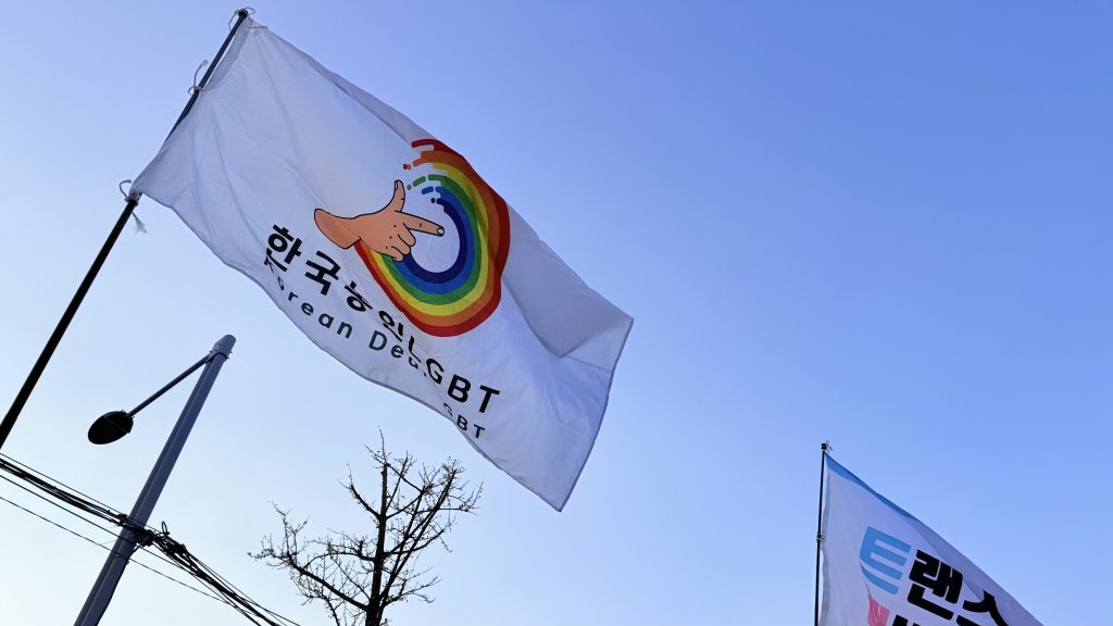 사진 설명 시작. 한국농인엘지비티플러스 깃발이 하늘에 휘날리고 있다. 사진 설명 끝.