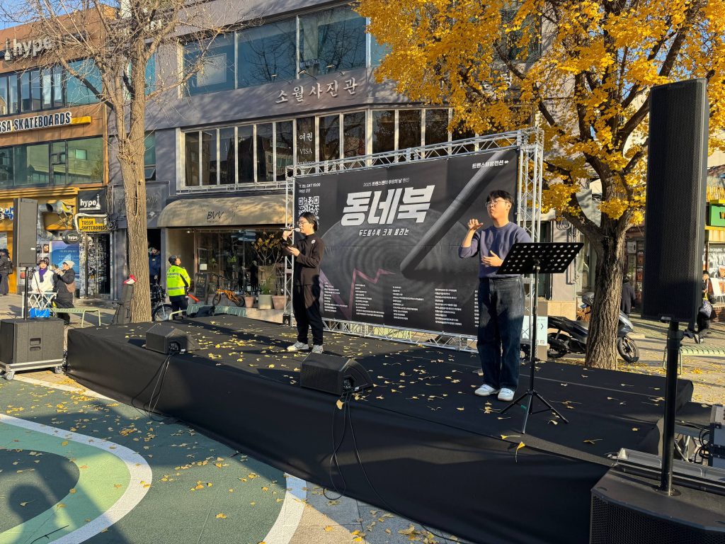 사진 설명 시작. 트랜스젠더 추모의 날 행진에서 해인 활동가가 무대에서 수어통역을 하고 있다. 사진 설명 끝.