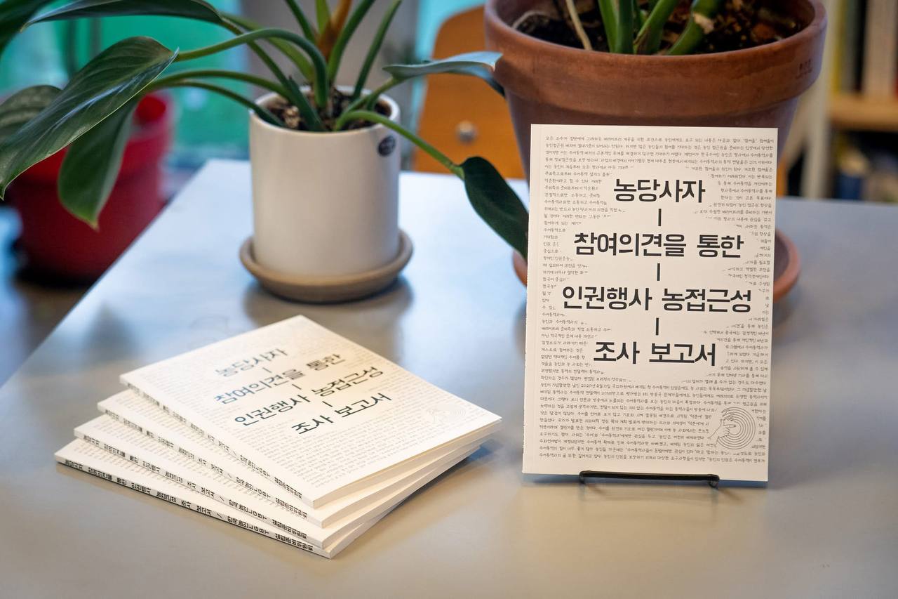 사진 설명 시작. 농당사자 참여의견을 통한 인권행사 농접근성 조사 보고서. 책자가 책상 위에 가지런히 놓여 전시되어 있다. 사진 설명 끝.